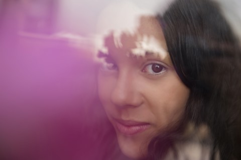 Smiling Hispanic woman behind window