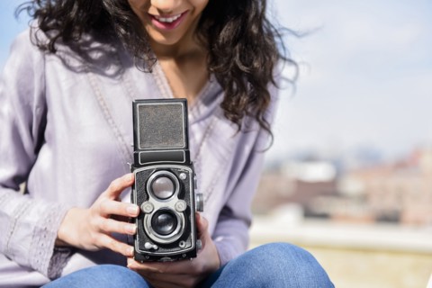 Hispanic woman using vintage camera