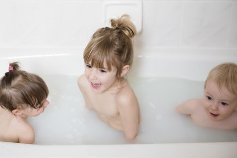 Smiling Caucasian boy and girls in bathtub