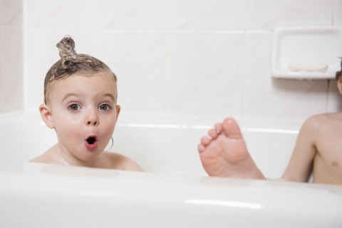 Surprised Caucasian girl in bubble bath