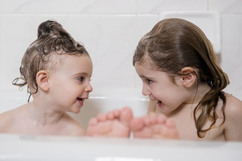 Smiling Caucasian girls in bathtub