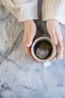 Hands of Caucasian woman holding cup of tea