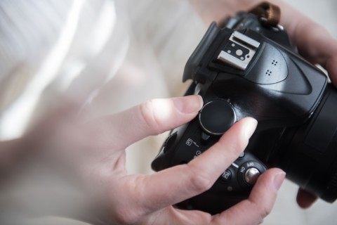 Hands of Caucasian woman turning dial on camera