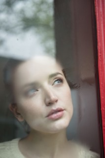 Caucasian woman daydreaming behind foggy window