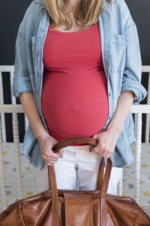 Caucasian expectant mother carrying bag