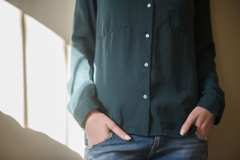 Midsection of Caucasian woman with hands in pockets
