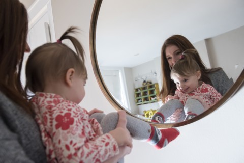 Reflection of Caucasian mother and baby daughter in mirror
