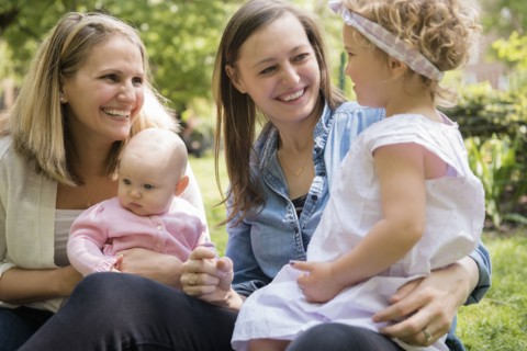 Caucasian mothers and daughters smiling in park