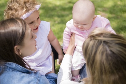 Caucasian mothers holding baby daughters