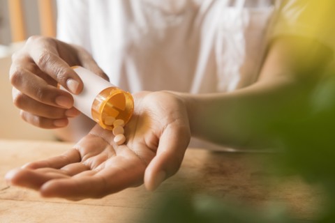 Hands of African American woman holding prescription medicine