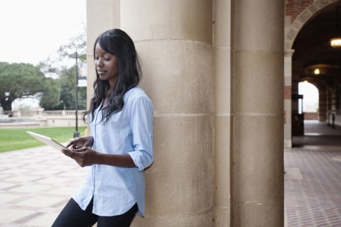 African American student using digital tablet outdoors