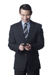 Chinese businessman text messaging on cell phone