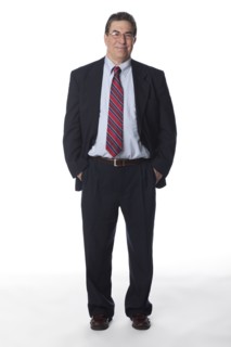Smiling businessman with hands in pockets