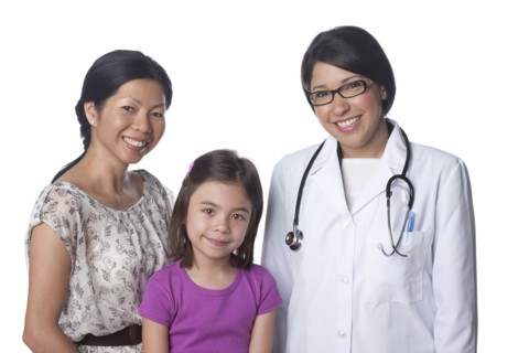 Smiling doctor standing with mother and daughter