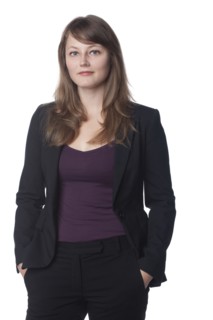 Serious businesswoman with hands in pockets