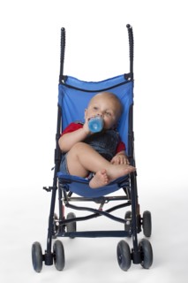 Caucasian baby boy in stroller drinking from bottle