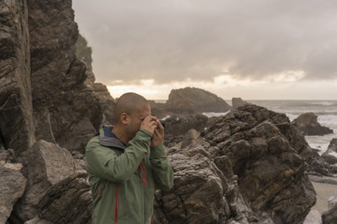 Chinese man photographing ocean