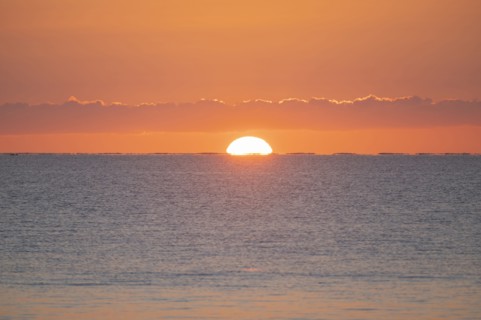 Sun rising above calm sea