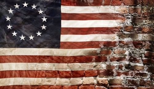 Betsy Ross flag with 13 stars on brick wall