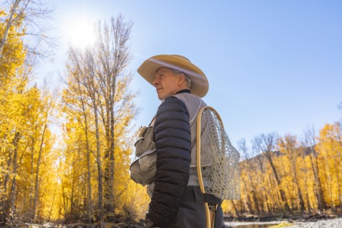 Senior fisherman in Autumn landscape