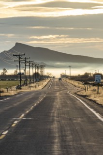 Rural road with mountain and morning mist in distance