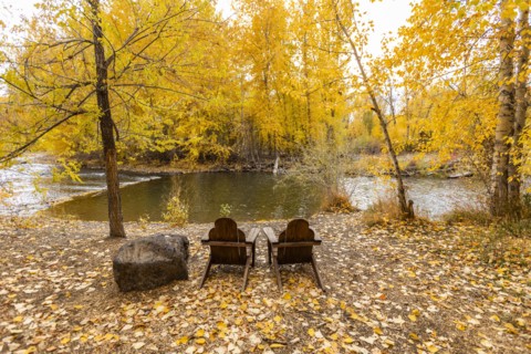 Two adirondack chairs facing Big Wood River