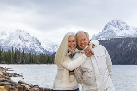 Portrait of smiling senior couple at mountain lake