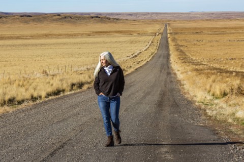 Senior woman walking down desert road