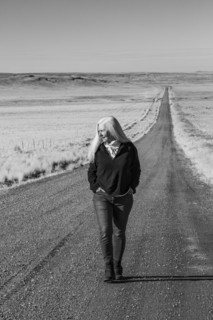 Senior woman walking down desert road