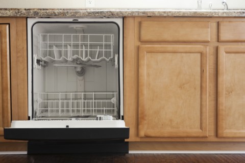 Empty open dishwasher in domestic kitchen