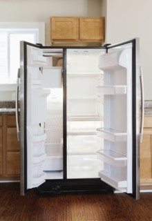 Empty open fridge in domestic kitchen