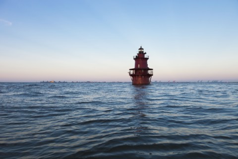 Red lighthouse in sea