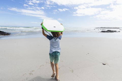 Boy with surfboard on beach