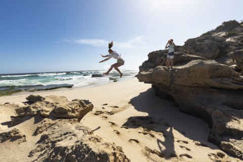 Girl jumping off rock