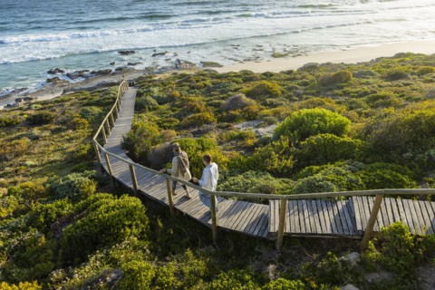 Mother and daughter walking on wooden bridge