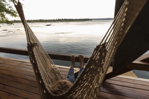 Boy relaxing in hammock by Zambezi River