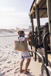 Woman unloading luggage off safari vehicle in Walker Bay Nature Reserve