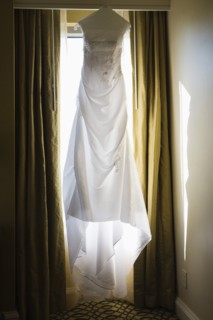 Wedding dress hanging against window