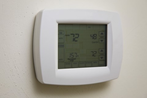 Home thermostat hanging on wall