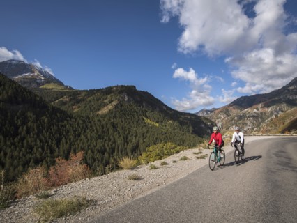 Man and woman riding bicycles on mountain road