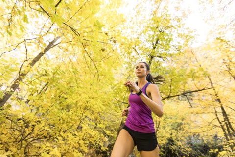 Woman jogging in Autumn forest