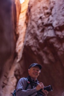 Senior male hiker with camera in canyon