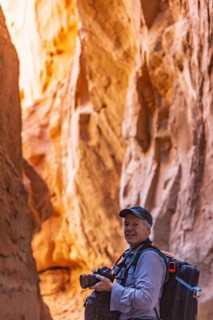 Senior hiker exploring and photographing rock formations in Kodachrome Basin State Park near Escalante Grand Staircase National Monument