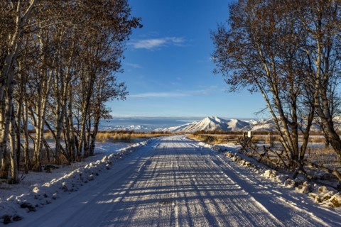 Country road leading to snowcapped mountains
