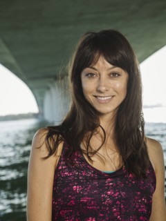 Portrait of smiling woman in sleeveless top under bridge