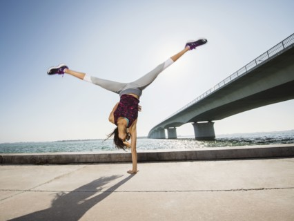Woman performing handstand outdoors