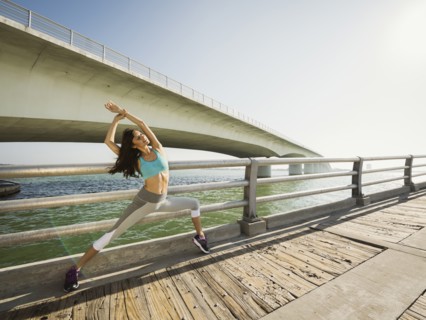 Woman stretching on bridge on sunny day