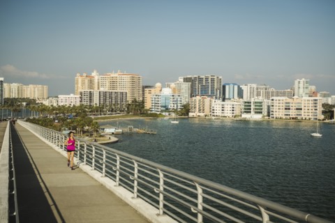Woman jogging on bridge on sunny day