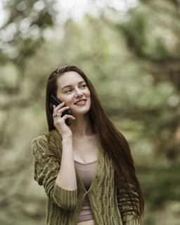 Smiling woman talking on phone in park