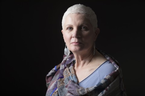 Studio portrait of woman with white short hair wrapped in shawl
